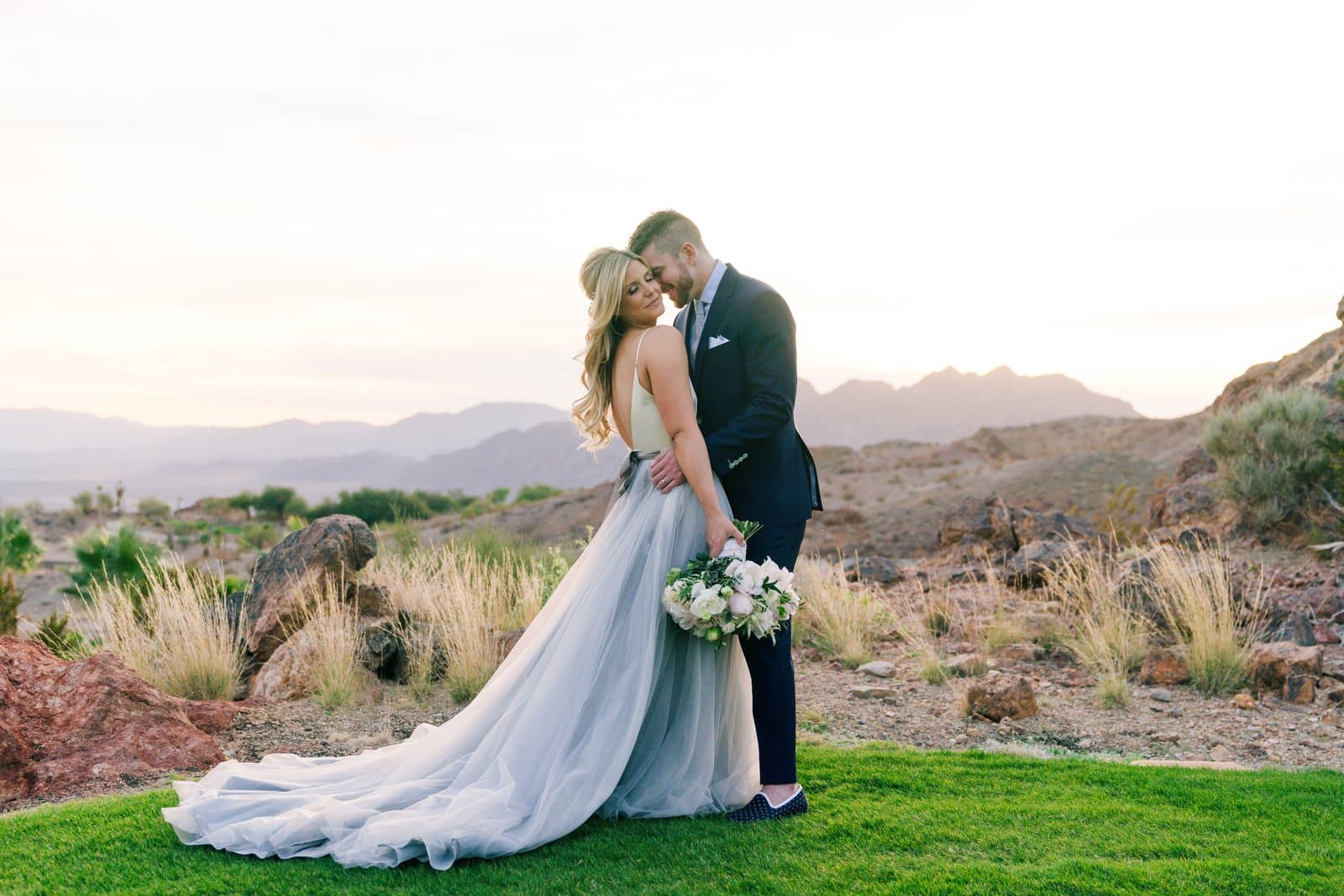 Heidi and Ryan embracing against the desert canyon at Cascata Golf Club on their Scheme Events wedding day